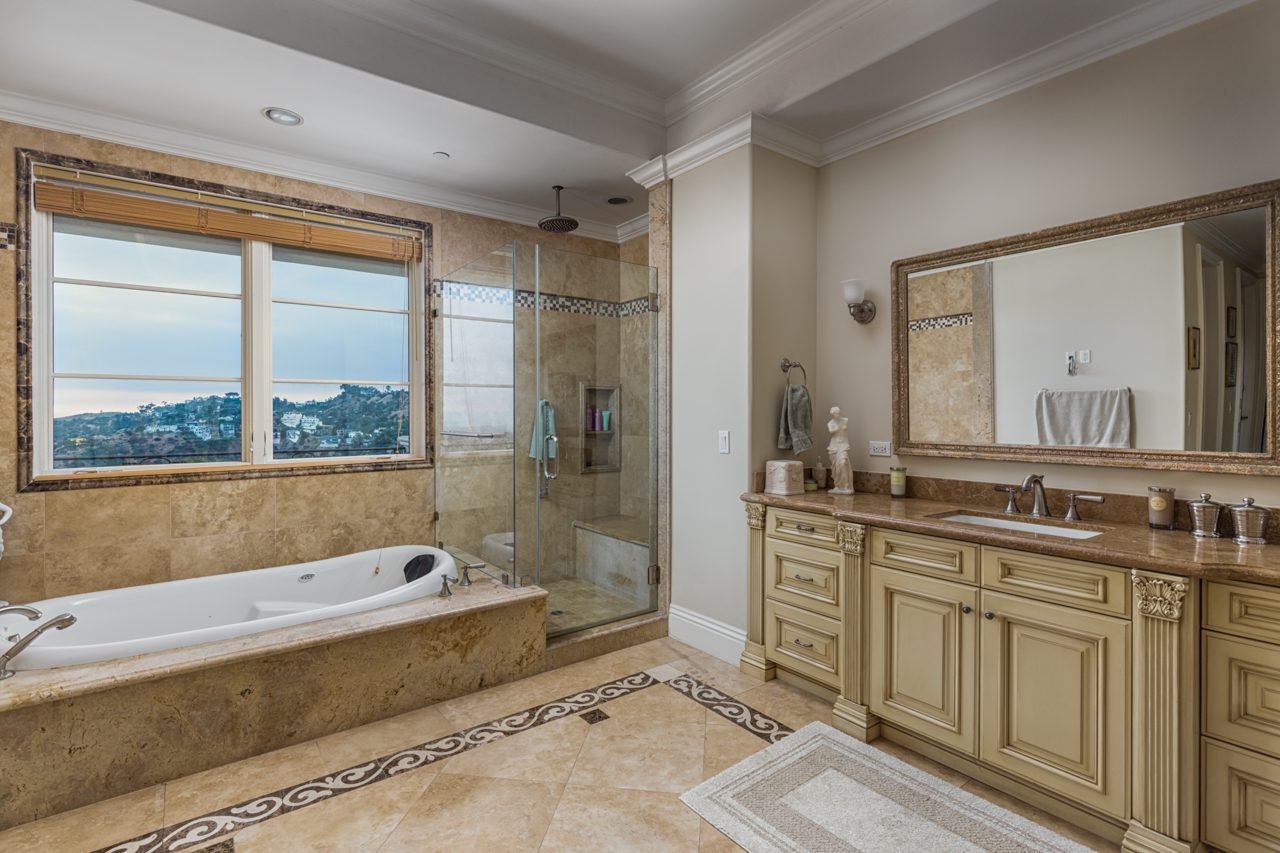 A bathroom with a tub, sink and shower.