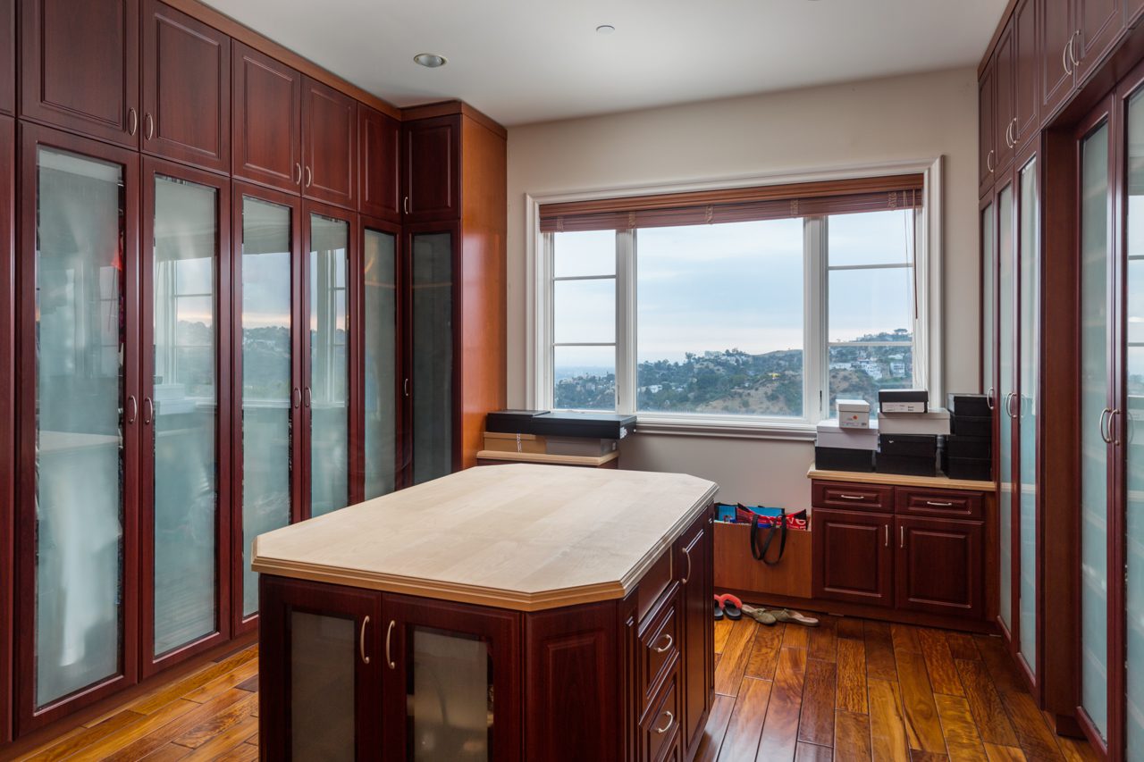 A kitchen with wooden cabinets and hardwood floors.